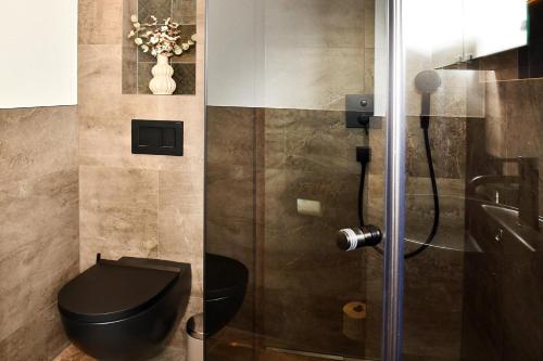 a bathroom with a black toilet and a shower at Appartement Edelschwarz in Westendorf