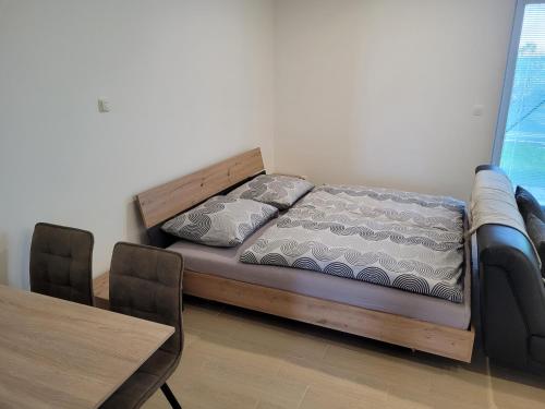 łóżko w pokoju ze stołem i tableablishthritisthritis sthritisthritis w obiekcie Apartmán Neva Galanta w mieście Galanta