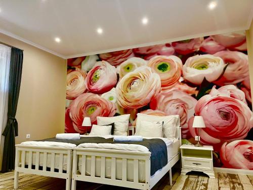 a bedroom with a wall mural of roses at Reforma Apartman in Szerencs