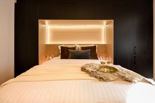 een slaapkamer met een bed met 2 glazen wijn bij Calea Victoriei Modern Studio - Escape in the City Center in Boekarest