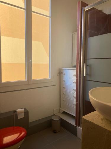 une salle de bain avec un lavabo et des toilettes et une fenêtre dans l'établissement appartement cosy, à Nice
