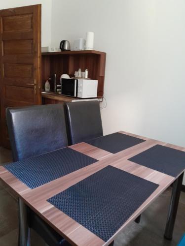 mesa de comedor con 2 sillas en Reforma Apartman, en Szerencs