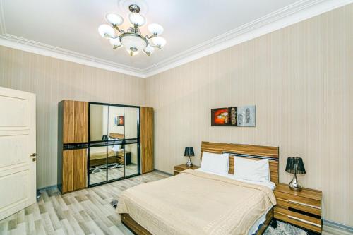 um quarto com uma cama e um lustre em Seaside Apartments em Baku