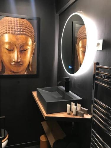 une salle de bain avec un lavabo noir et un miroir dans l'établissement La Petite Suite, à Cannes