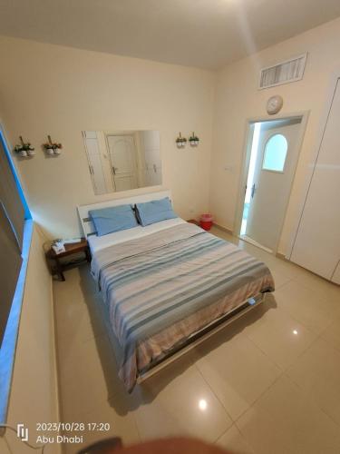 1 dormitorio con 1 cama grande con almohadas azules en Master room 1, Couples should be married, en Abu Dabi