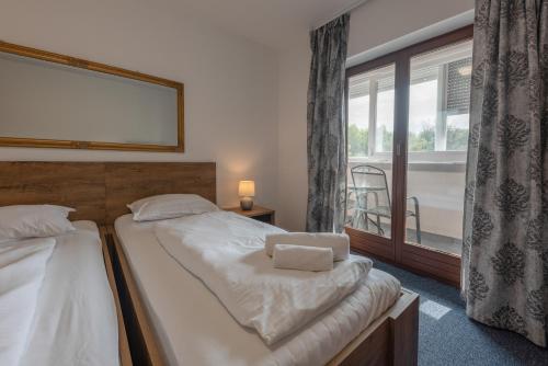 a bedroom with two beds and a large window at Aparthotel Plat in Kožino