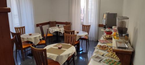 un restaurante con mesas y sillas con comida. en House 4 Mori, en Roma