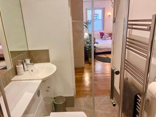 ein weißes Badezimmer mit einem Waschbecken und einem Spiegel in der Unterkunft Shoreditch Private Studio in London