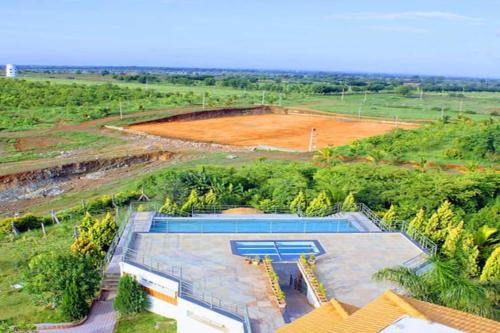 een uitzicht over een zwembad in een veld bij Nikhara Fort Resorts in Penukonda