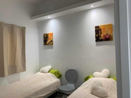 two twin beds in a room with white walls at Bungalow enfrente piscina en Maspalomas in Maspalomas