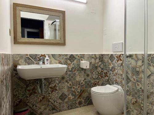 uma casa de banho com um lavatório, um WC e um espelho. em Davis Apartment em Brindisi