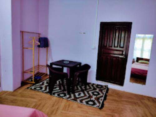 Pokój ze stołem, krzesłami i drzwiami w obiekcie Chawngthu Lodge,Aizawl w Aizawl