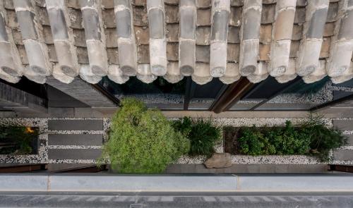 a building with stairs and a roof with plants at Jingmao Alley Hotel - Beijing Wangfujing Dongsi Subway Station Branch in Beijing