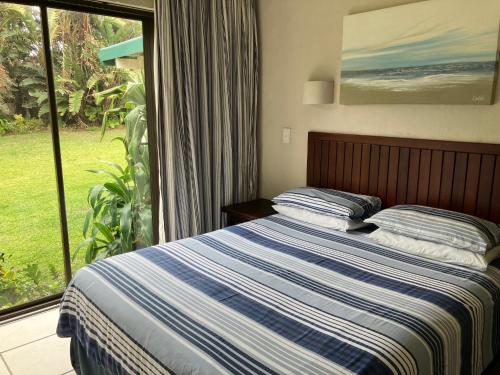 a bedroom with a bed and a large window at The Sea Cottage in Marina Beach