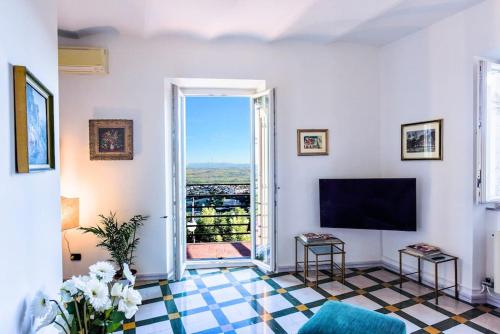 ein Wohnzimmer mit einem großen Fenster und einem TV in der Unterkunft Grand Horizon Palace - in centro con panorama TOP in Osimo