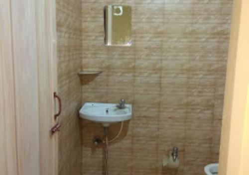 a bathroom with a sink and a toilet at Hotel Basera Odisha in Rourkela