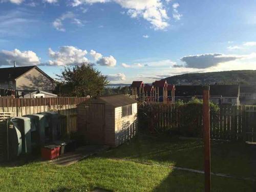 a backyard with a fence and a yard withgrass at 31 end terrace. in Whitehead
