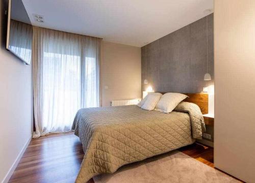 a bedroom with a bed and a large window at Martin Deuna Etxea- Piso en zona residencial in Bermeo