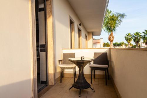 a patio with a table and chairs on a balcony at Hotel Premiere in Marina di Varcaturo