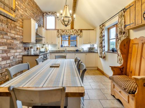 a kitchen with a large wooden table and chairs at The Barn- Uk45536 in Buildwas