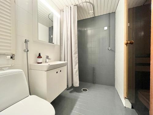 a white bathroom with a toilet and a shower at Tammer Huoneistot - City Suite 1 - Sauna, Balcony & Free parking in Tampere