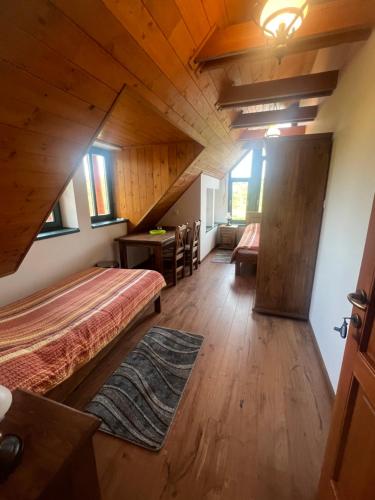 1 dormitorio en el ático con 2 camas y mesa en Vendégház Petörke, en Bárdudvarnok