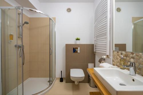 a bathroom with a shower and a toilet and a sink at RentPlanet - Studio Górna Resorts in Szklarska Poręba