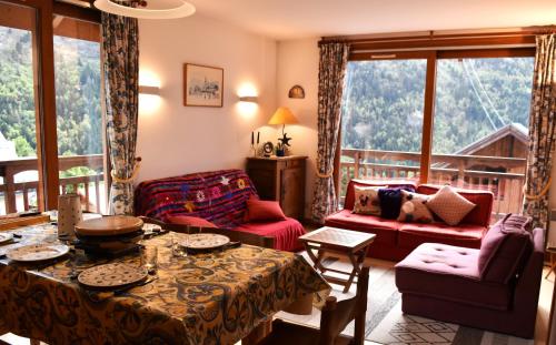 un salon avec un canapé, une table et des chaises dans l'établissement VAUJANYLOCATIONS - CLARET 2 APT 15, à Vaujany