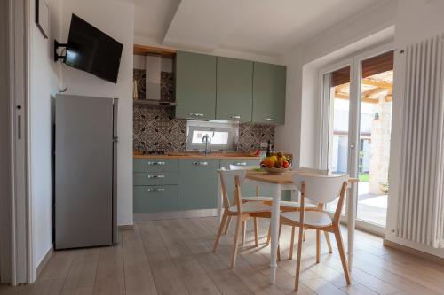 a kitchen with green cabinets and a table and chairs at Casa Valerio in Conversano