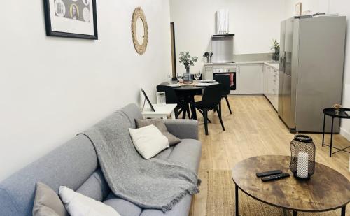 Il comprend un salon avec un canapé bleu et une cuisine. dans l'établissement Sublime Appartement 2 pièces au cœur de la Vieille Ville, à Nice