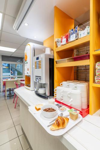 a kitchen with a counter with food on it at Premiere Classe Deauville Touques in Deauville