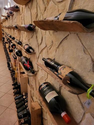 a row of wine bottles hanging on a wall at Dimora da Capo Appartamento in Villa in Casoli