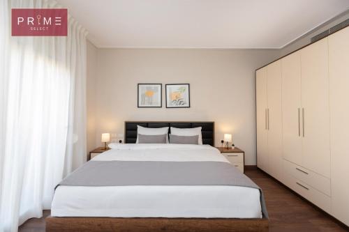 a bedroom with a large bed and white walls at Prime Select New Giza in Giza