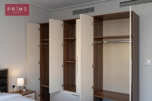 a bedroom with wooden closet doors in a room at Prime Select New Giza in Giza