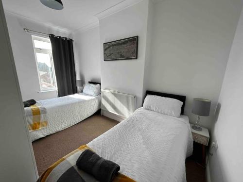 um quarto com 2 camas e uma janela em 74 Ashby House 3 bed townhouse em Brumby