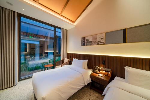 a hotel room with two beds and a large window at Jingmao Alley Hotel - Beijing Wangfujing Dongsi Subway Station Branch in Beijing