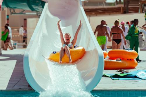 a young boy is riding on an inflatable raft in a pool at Pickalbatros The Palace Port Ghalib in Port Ghalib