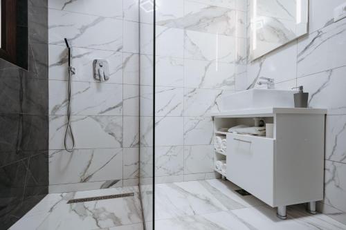 bagno bianco con doccia e lavandino di NOR Villa a Ciungetu