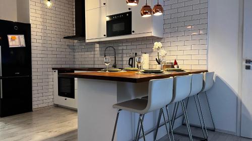 a kitchen with a counter with stools in it at APARTMENT KRISTINA in Dunajská Streda