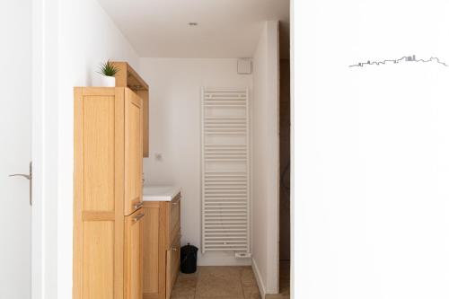 a bathroom with a sink and a wooden cabinet at Mas lou Félibrige in Venelles