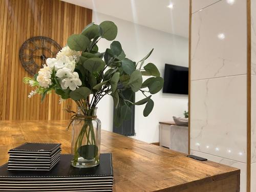 a vase filled with white flowers on a table at Broadway Beach Home with Hot tub in Herne Bay