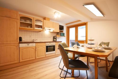 a kitchen with a table and chairs in a room at Almliesl NEUK-467 in Neukirchen am Großvenediger