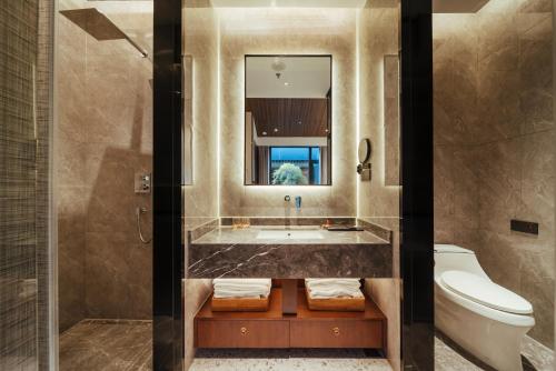 ein Badezimmer mit einer Badewanne, einem WC und einem Waschbecken in der Unterkunft Jingmao Alley Hotel - Beijing Wangfujing Dongsi Subway Station Branch in Peking