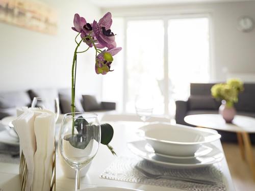 a table with a plate and a vase with a flower at VacationClub - Apartamenty Piano Apartament 3 in Świeradów-Zdrój