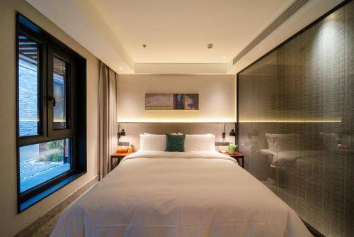 a bedroom with a large white bed and a window at Jingmao Alley Hotel - Beijing Wangfujing Dongsi Subway Station Branch in Beijing