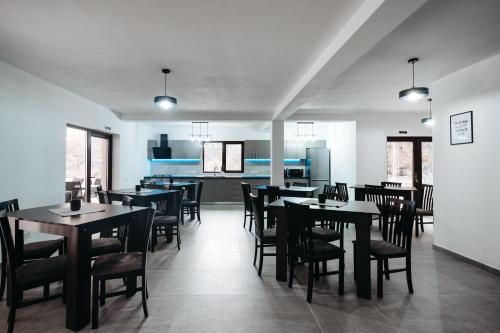 una sala da pranzo con tavoli e sedie e una cucina di NOR Villa a Ciungetu