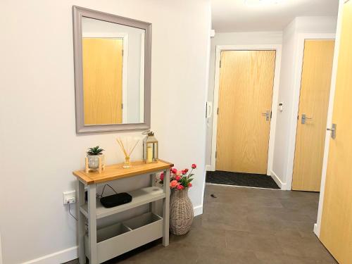 a bathroom with a table and a mirror on the wall at Superb 2 bed 2 bathroom free parking in Derby