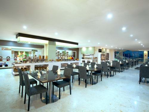 a dining room with tables and chairs in a restaurant at Platinum Hotel & Convention Hall Balikpapan in Balikpapan