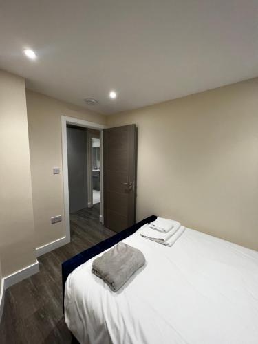 Un dormitorio con una cama blanca con una toalla. en Flat in London en Londres