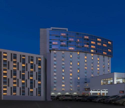 Un grand bâtiment avec des voitures garées dans un parking dans l'établissement Wyndham Fallsview Hotel, à Niagara Falls